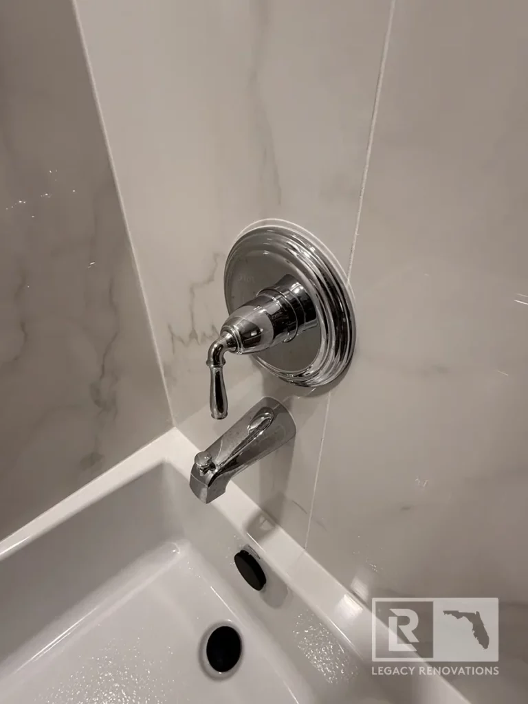 Chrome tub-shower control and spout mounted on marble-look wall tile in San Jose, Jacksonville, FL