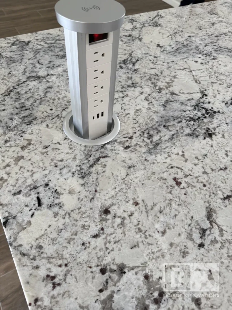 Sleek, retractable pop-up outlet with multiple power and USB ports, seamlessly integrated into a beautiful granite or quartz countertop.