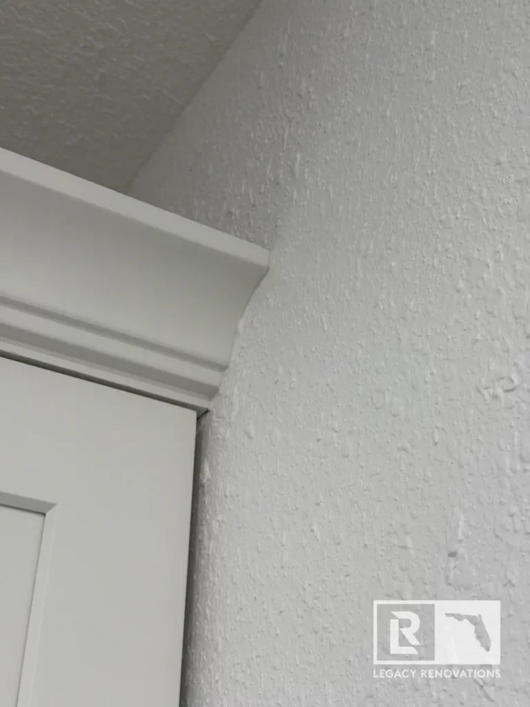 White cabinet trim beside a textured wall and ceiling corner in St. John, Jacksonville, FL
