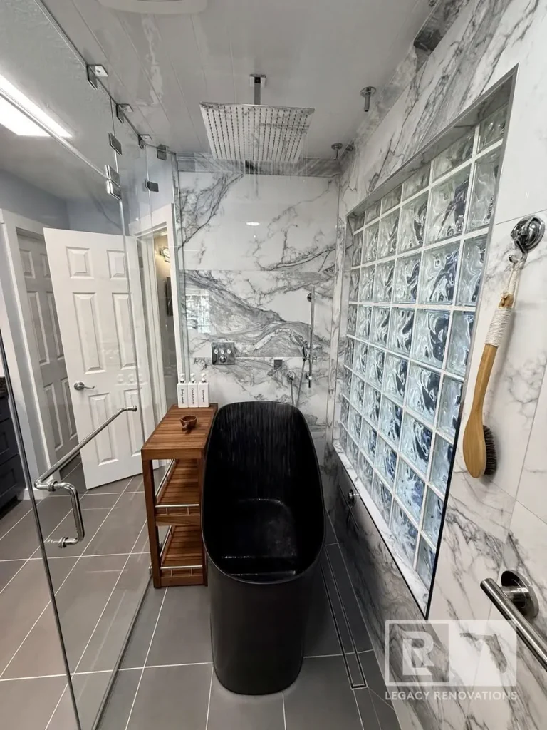 Jacksonville, FL bathroom remodel with black freestanding tub, glass shower enclosure, marble-look walls, and glass block window