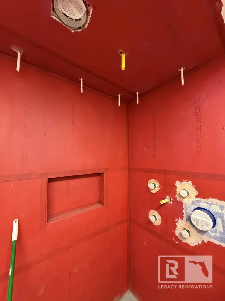 Custom shower waterproofing with RedGard membrane, recessed shower niche, and plumbing rough-in before tile installation in Jacksonville, FL.