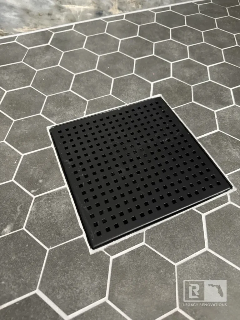 Gray hexagon tile shower floor with a black square drain in Jacksonville, FL