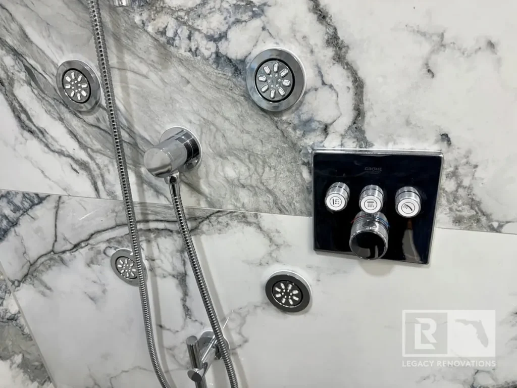 Luxury shower system with body sprays, handheld shower, and multi-function control valve installed on marble-look tile in Jacksonville, FL.