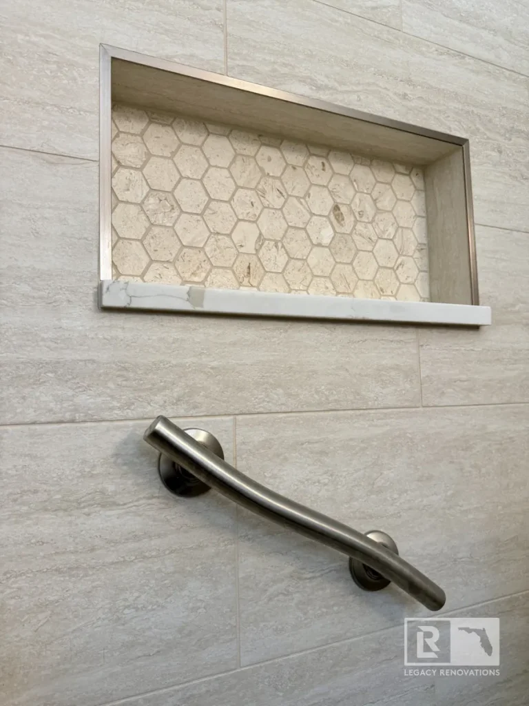 Recessed shower niche with hexagon tile and horizontal metal grab bar in Jacksonville, FL