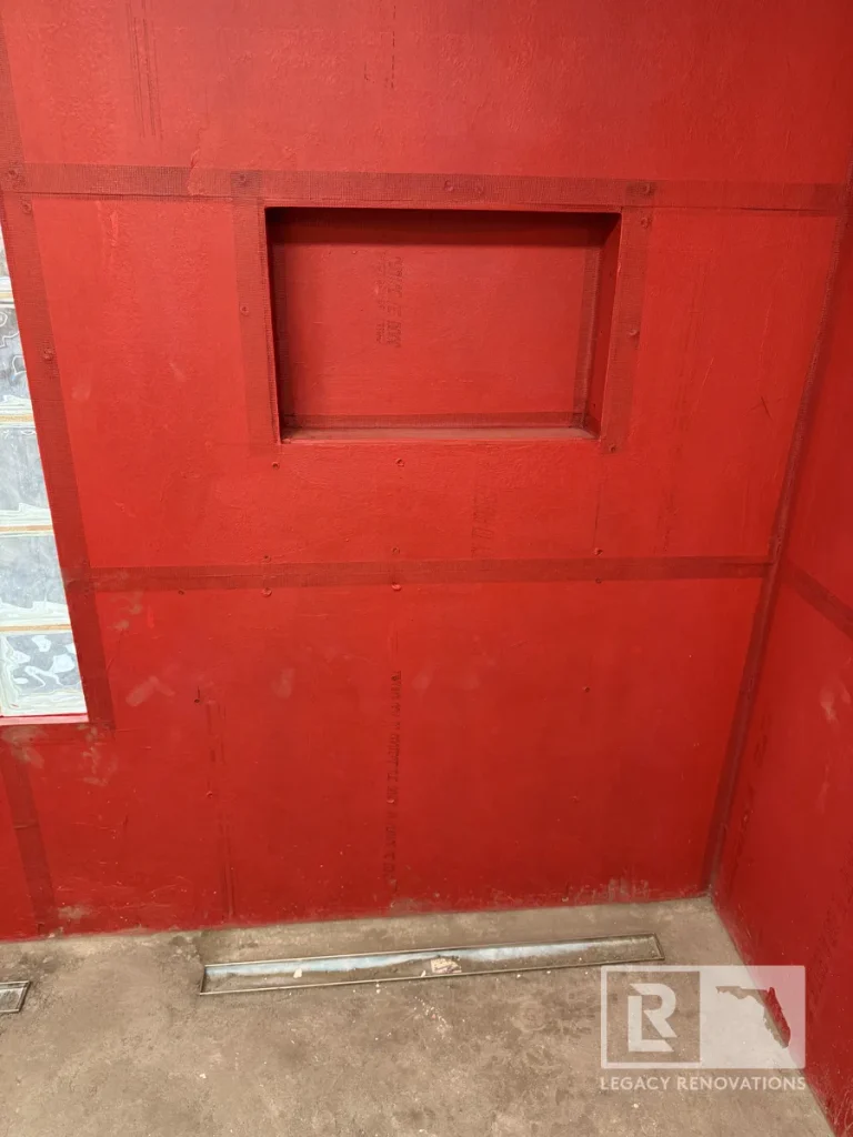 Custom shower waterproofing using RedGard membrane with a recessed shower niche and linear drain during a bathroom remodel in Jacksonville, FL.