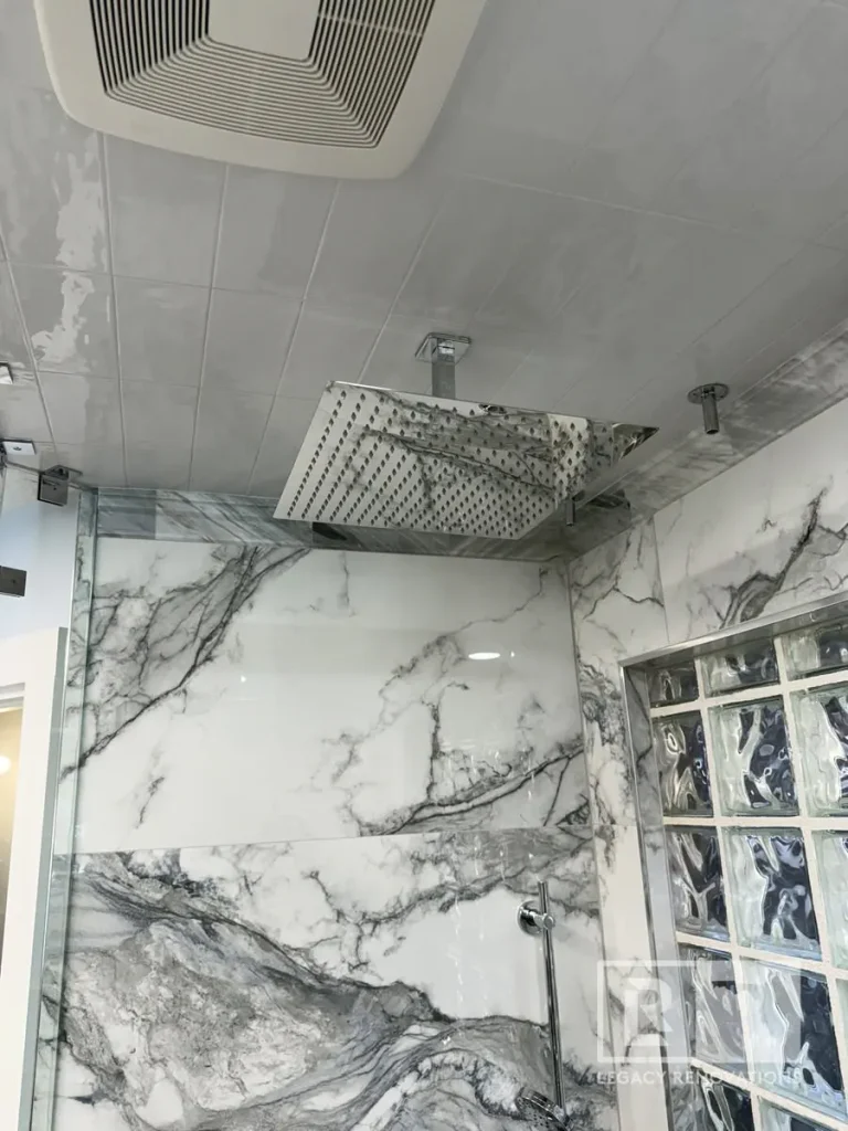 White marble wall shower with square rainfall showerhead and glass block window in Jacksonville, FL