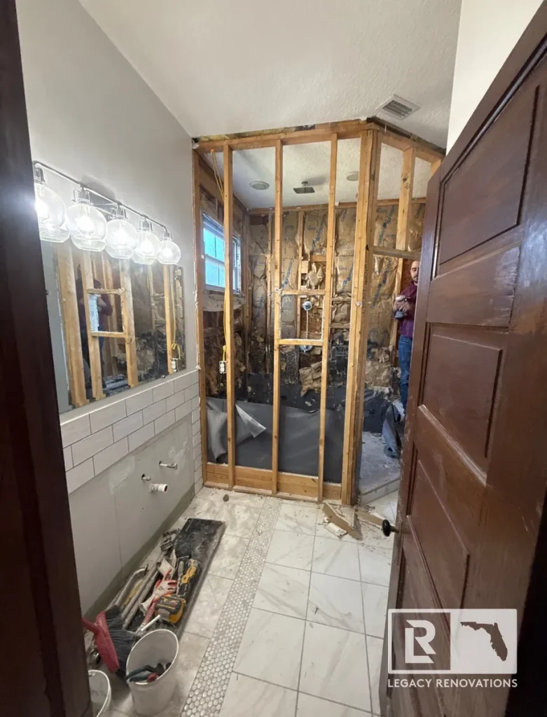 Bathroom remodeling in progress with new wall framing, exposed shower area, and vanity preparation in Jacksonville, FL.