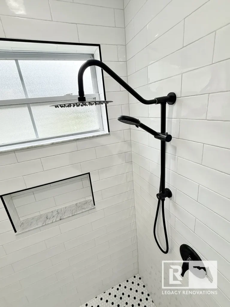 Modern walk-in shower with white subway tile, matte black rainfall shower system, custom recessed niche, and penny tile flooring.