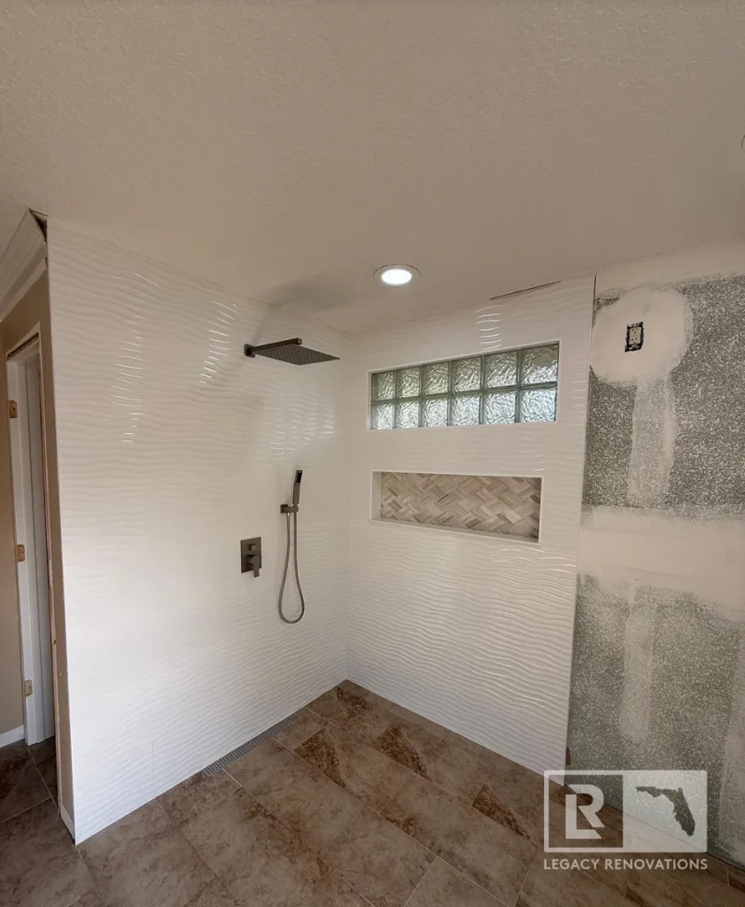 Finished walk-in shower with wave tile, niche, and matte black fixtures in Jacksonville, FL.