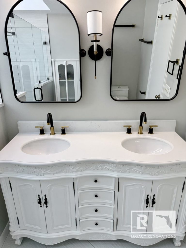 Custom vintage-style white bathroom double vanity with quartz countertops and matte black fixtures in a Jacksonville, Florida home renovation.