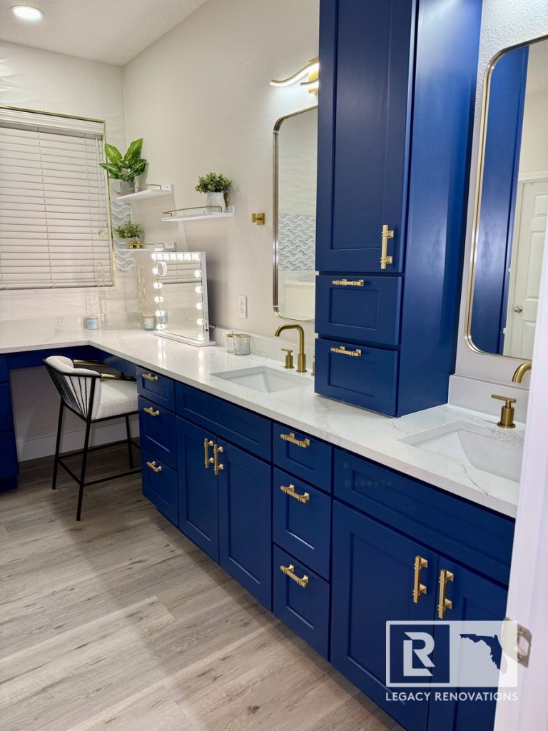 Custom navy blue double vanity with a white quartz countertop, brushed brass hardware, and a built-in makeup station in a Jacksonville, Florida bathroom remodel.