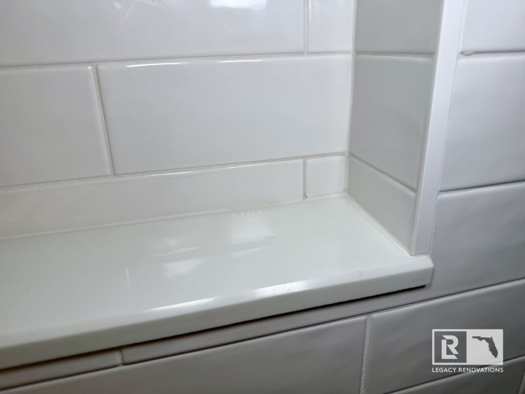 Custom shower niche with glossy white subway tile in a modern bathroom remodel completed in Jacksonville, Florida.