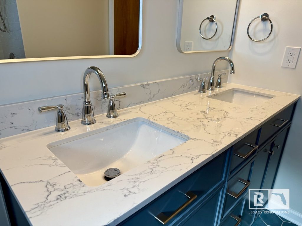 Modern double bathroom vanity with a quartz countertop, undermount sinks, brushed nickel faucets, and custom blue cabinetry in a Jacksonville, Florida bathroom remodel.