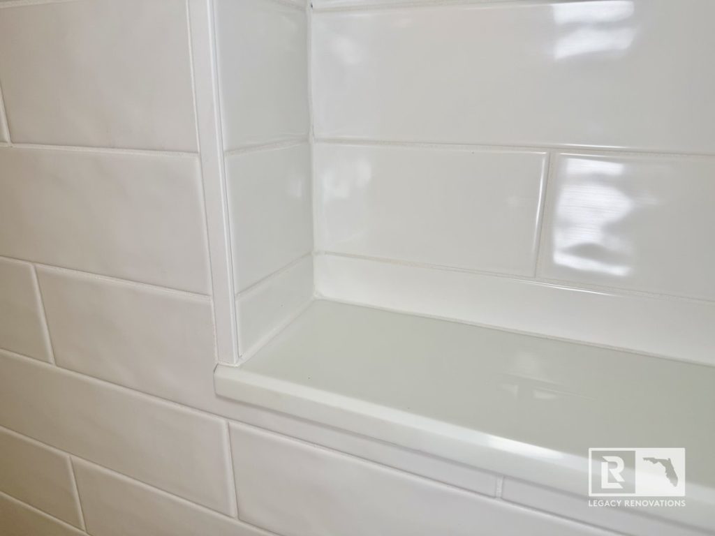 Modern bathroom remodel in Jacksonville, Florida featuring glossy white subway tile walls and a custom recessed shower niche with clean contemporary finishes.