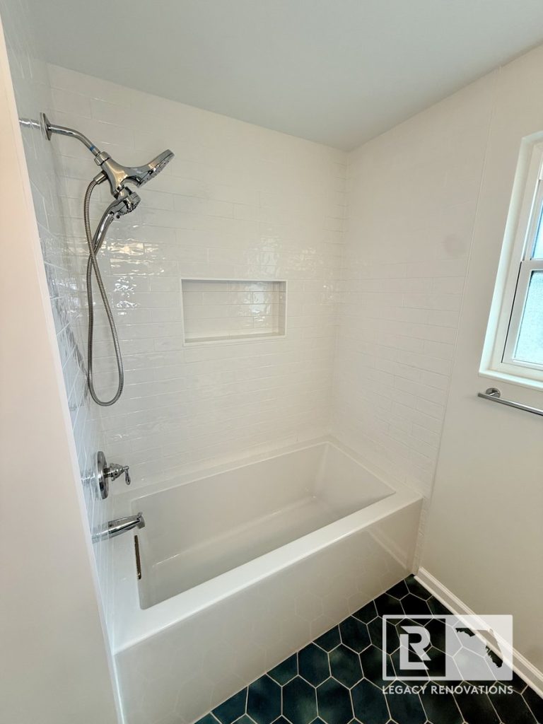 Modern bathtub and shower remodel in Jacksonville, Florida featuring glossy white subway tile, a custom recessed shower niche, chrome fixtures, and a deep soaking tub.