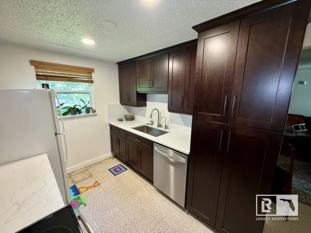 Traditional modern - Kitchen renovation with tall espresso pantry cabinets, quartz countertops, stainless steel dishwasher, and modern storage solutions.