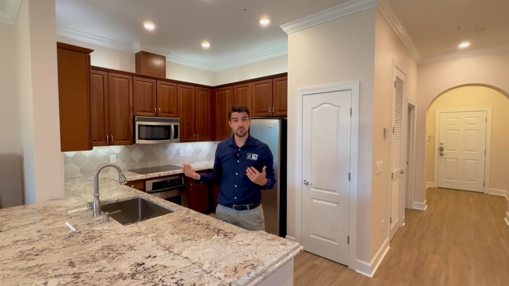 Luxury kitchen featuring dark wood cabinets, granite countertops, stainless steel appliances, and an open-concept layout.