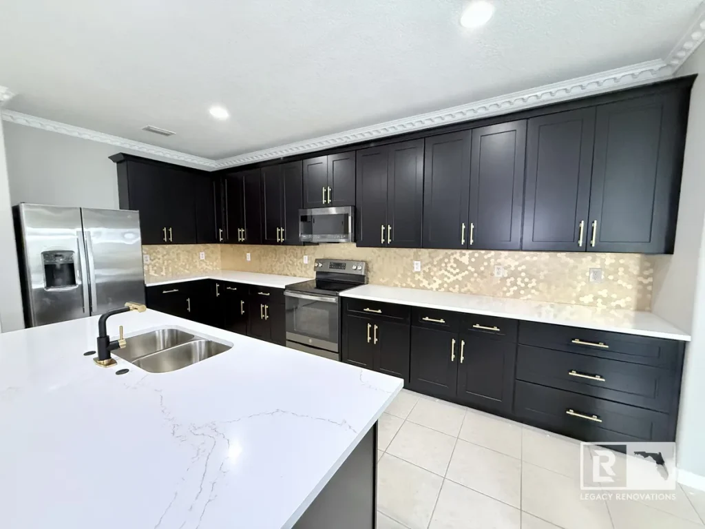Black shaker kitchen cabinets, white quartz island counter with sink, and beige tile backsplash.